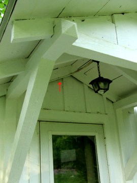 The Guest House portico where I watched a phoebe nest; the arrow points to the location of a bat which also chose to nest under the roof another time 